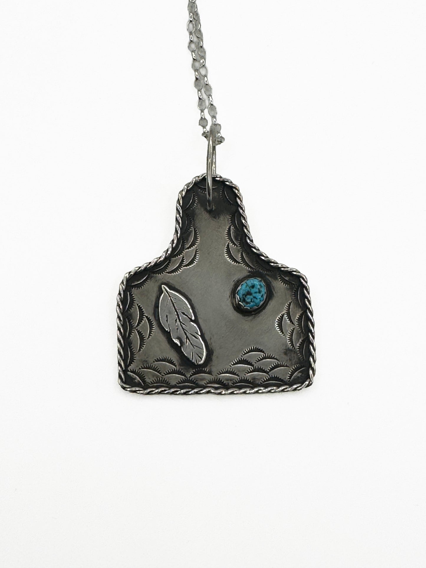Cow Tag Pendant with Kingman Turquoise and feather on the left